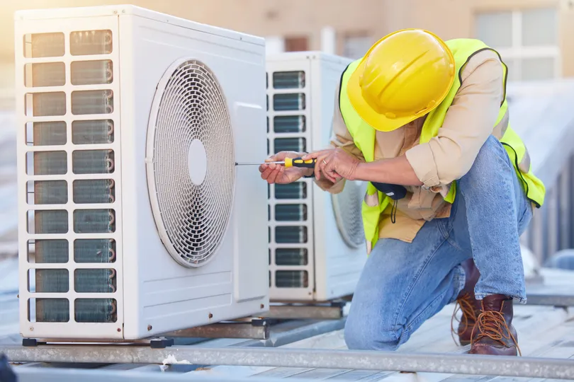 An AC repairman working on a unit in Florida