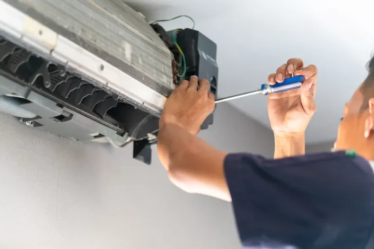 Repairman working on an AC unit in Astor