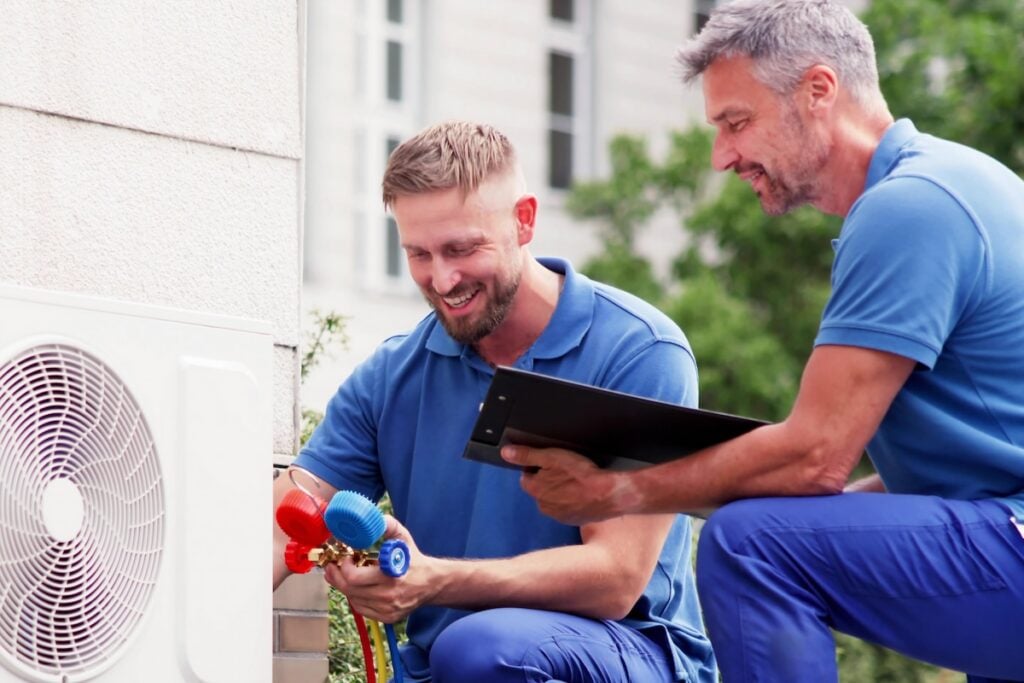 experienced technicians installing heat pump
