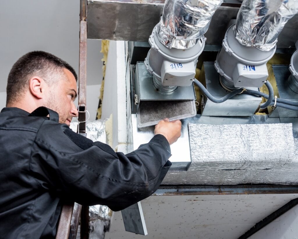 Ventilation cleaning. Specialist at work. Repair ventilation system (HVAC). Industrial background