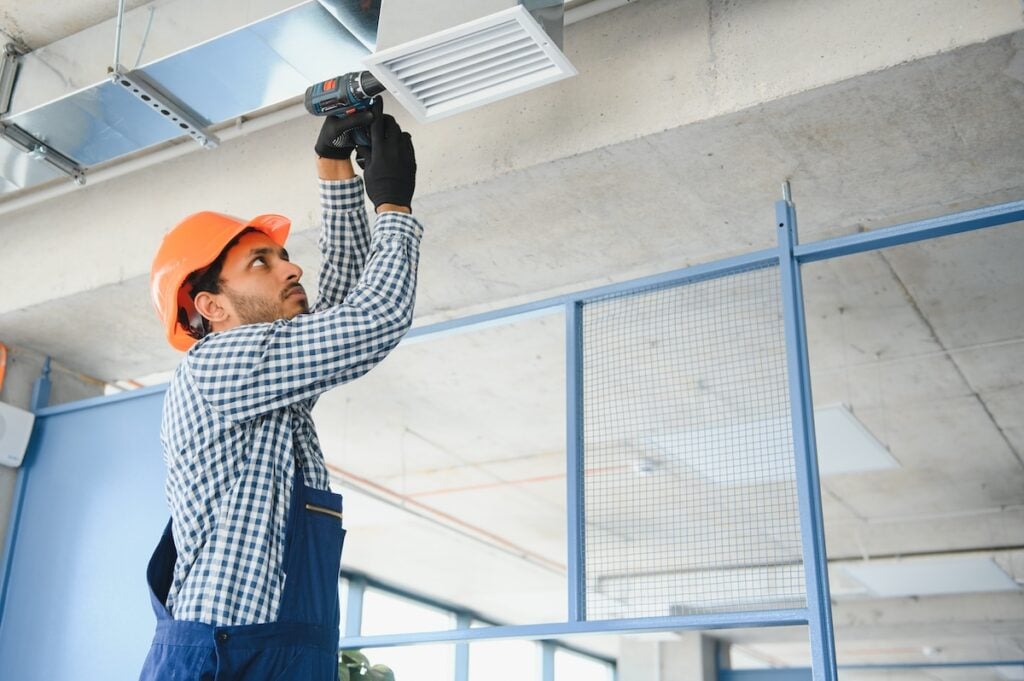Ventilation cleaning. Specialist at work. Repair ventilation system (HVAC). Industrial background.