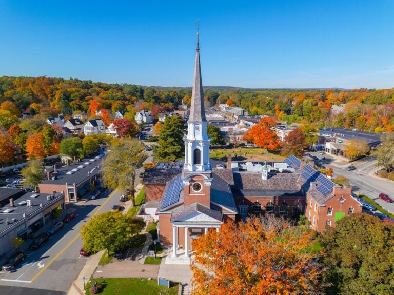 a church with a steeple and trees in the background