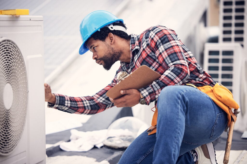 Technician, clipboard or air conditioning inspection on rooftop for safety, power or maintenance. Electrician, black man or paperwork on hvac system, ac repair or quality assurance for sustainability.