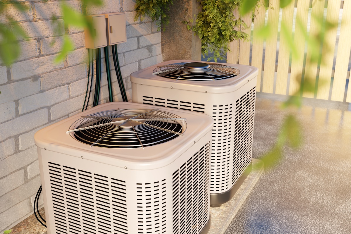 Two condensers. Air conditioning pumps near wall. Ventilation blocks for pumping air. Condensers for temperature control. Conditioning technologies. Climate equipment near house with fence.