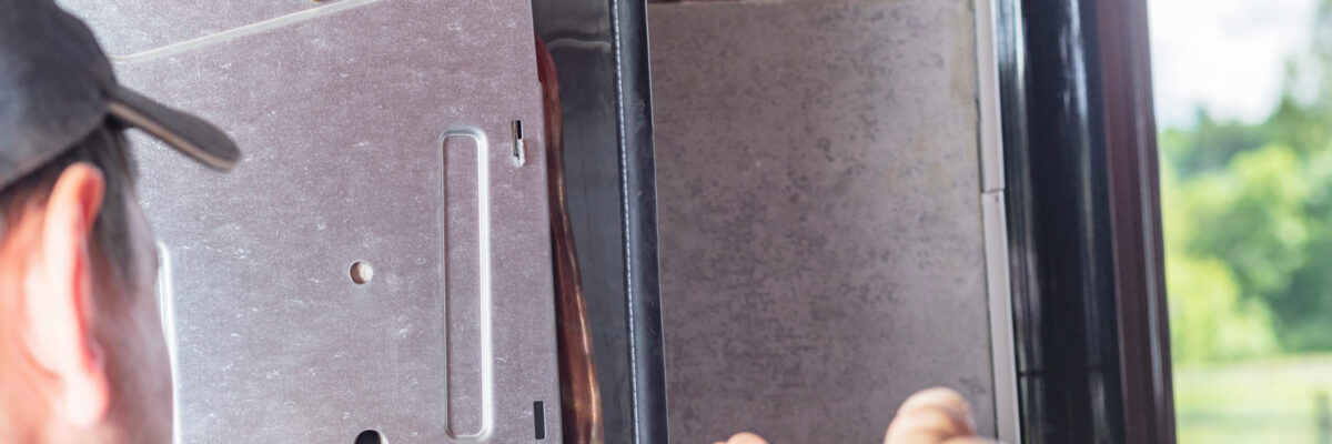 The master sets up a gas boiler, which weighs on the wall. The front dashboard is open. The removal and installation of gas nozzles for gas supply.