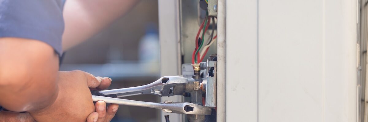 Technician man using a wrench fixing modern air conditioning system, Maintenance and repair concept