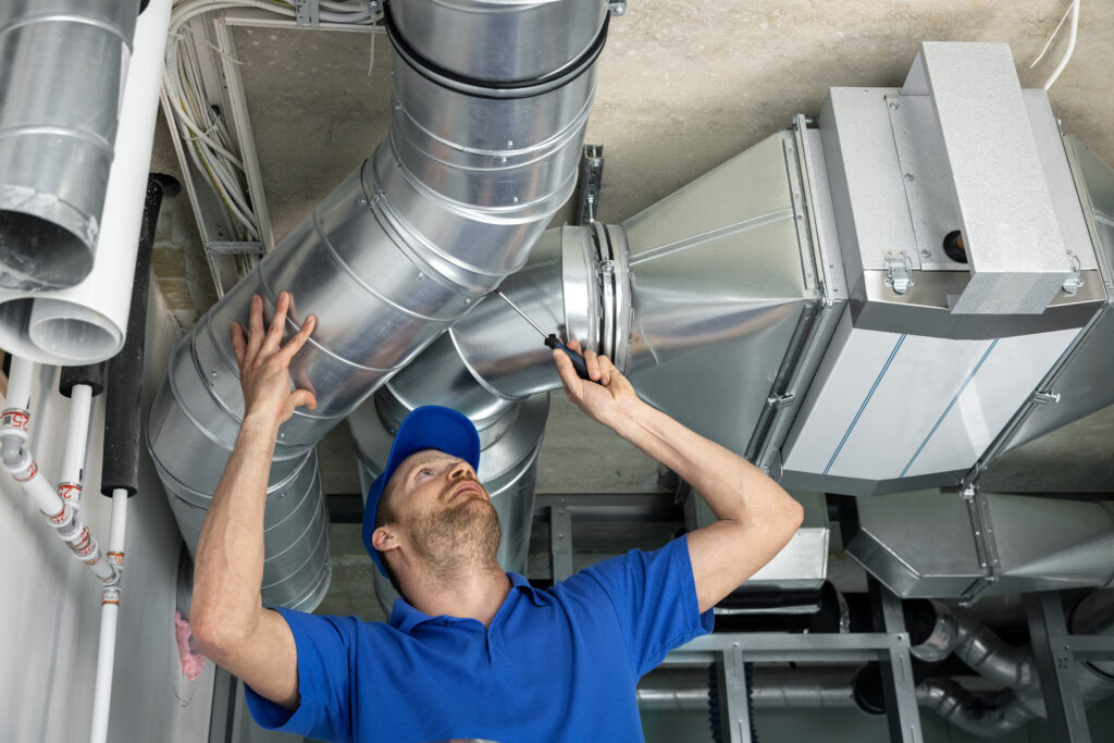 how to clean air ducts hvac services - worker install ducted pipe system for ventilation and air conditioning in house