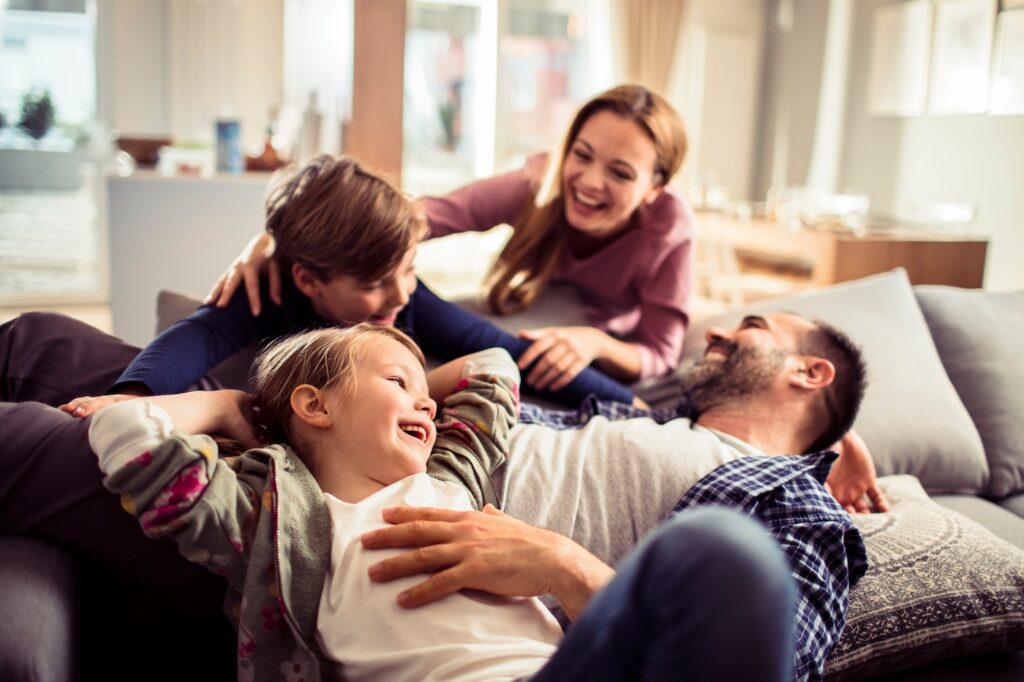 Happy young family relaxing on the couch together at home