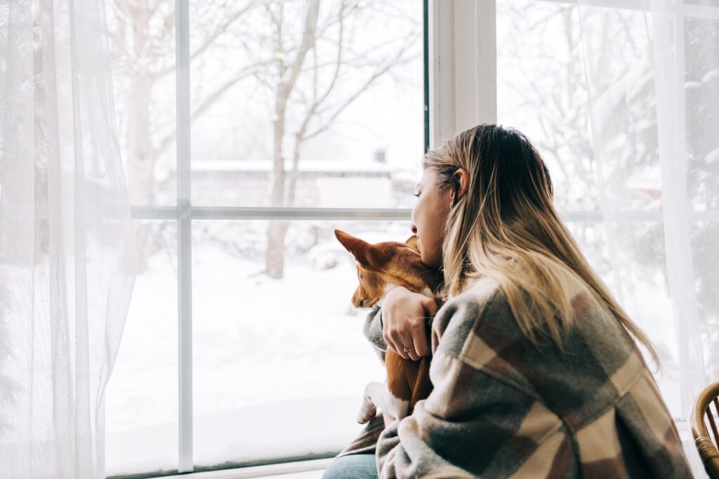 woman and dog at house in winter