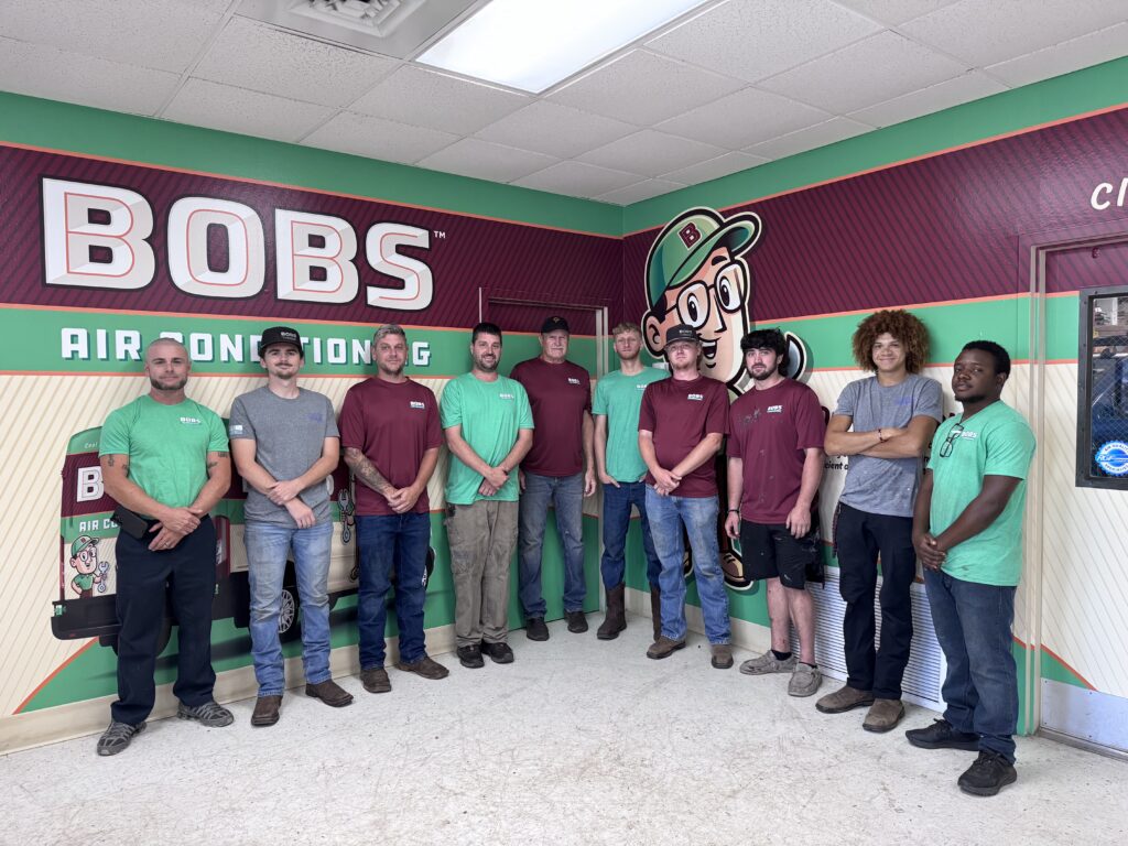 Bob's Ac team standing next to wall