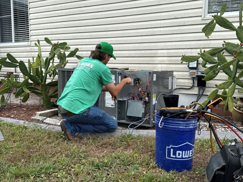 outside ac unit not turning on big siding house Bob's AC worker inspecting