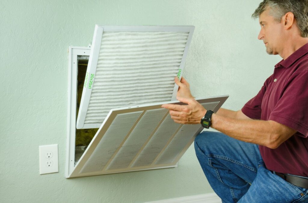 ac running but not cooling house man checking filters