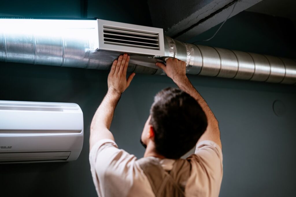 duct work wildwood fl worker checking vent on modern house
